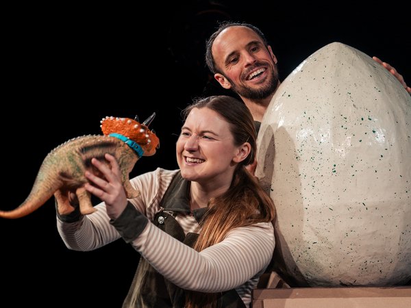 Ein Mann und eine Frau mit einem riesigen Ei und einem kleinen Dino
