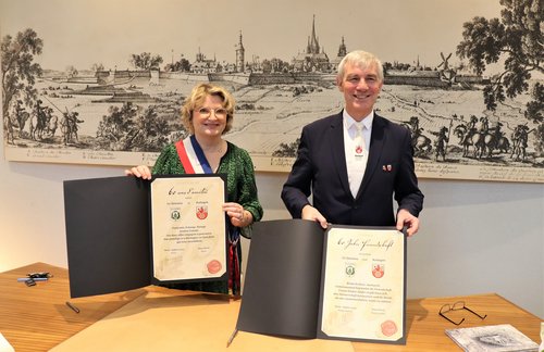Mann und Frau halten Urkunden in den Händen