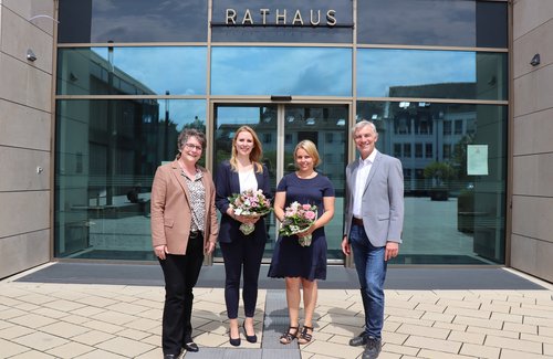Drei Frauen und ein Mann vor dem Rathaus