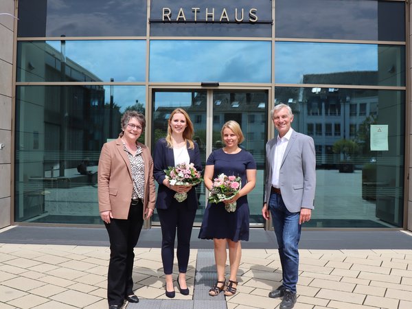 Drei Frauen und ein Mann vor dem Rathaus