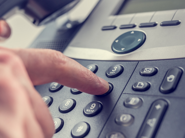 Finger tippt auf einer Telefon-Tastatur