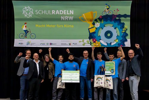 Jubelnde Personengruppe auf einer Bühne