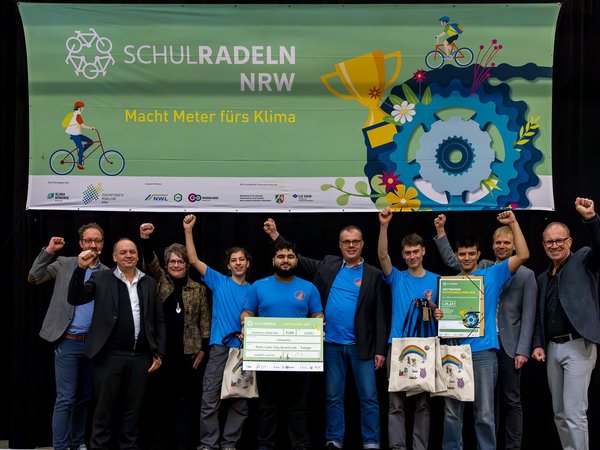 Jubelnde Personengruppe auf einer Bühne