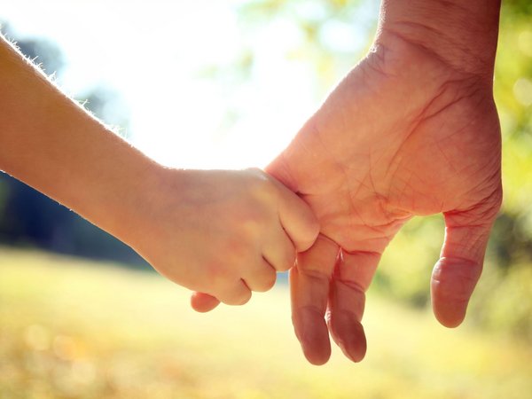 Eine Kinderhand liegt in einer Erwachsenenhand