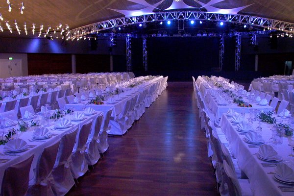Festlich dekorierte Tische und Stühle im Saal der Stadthalle