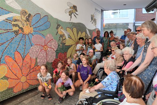 Kinder und ältere Menschen beim Mosaik-Kunstwerk