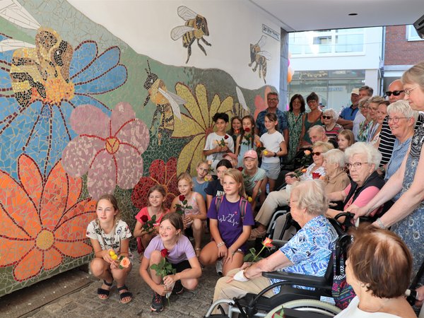 Kinder und ältere Menschen beim Mosaik-Kunstwerk