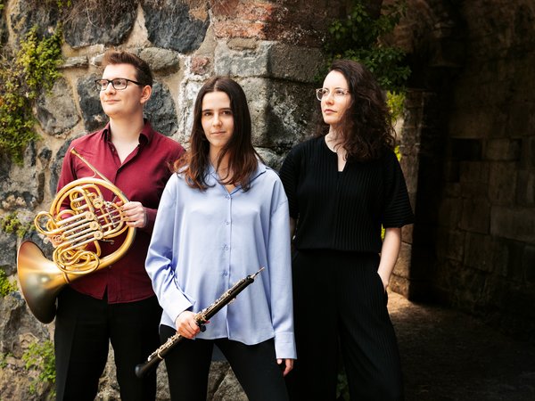 Mann mit Horn und zwei Frauen, eine mit Oboe in der Hand