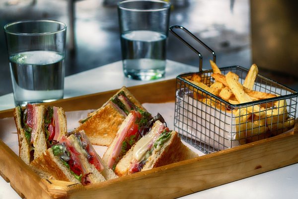 Tablett mit Sandwich, Pommes und Wassergläsern