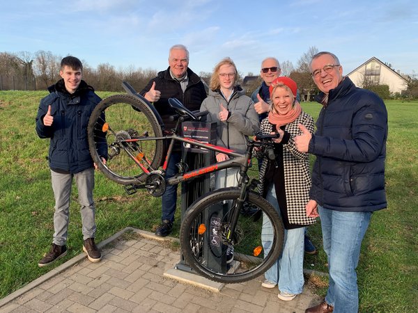 Mehrere Personen stehen um ein Fahrrad herum  