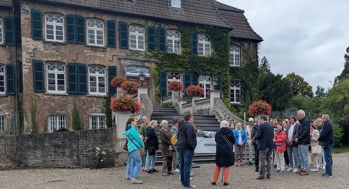 Menschen bei einer Führung vor einem Schloss