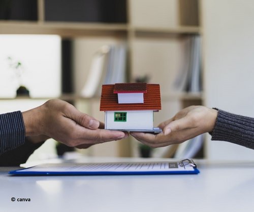 Zwei Hände halten ein Miniaturhaus 