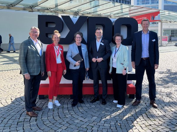 Mehrere Personen vor dem Schriftzug EXPO