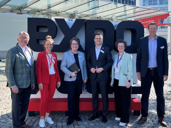 Mehrere Personen vor dem Schriftzug EXPO