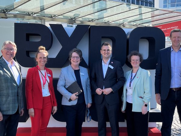 Mehrere Personen vor dem Schriftzug EXPO