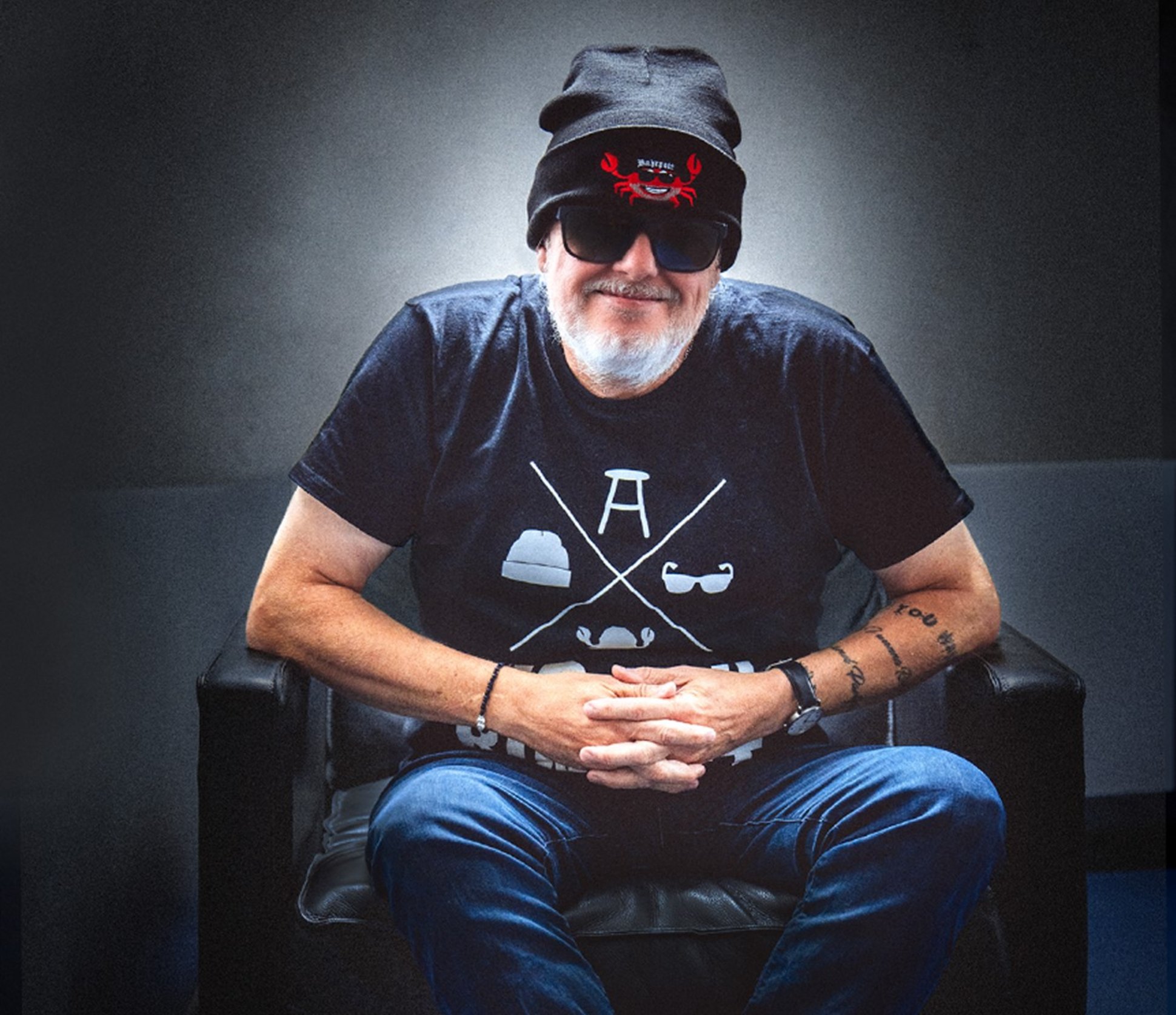 Markus Krebs sitzt auf einem Stuhl und lächelt.