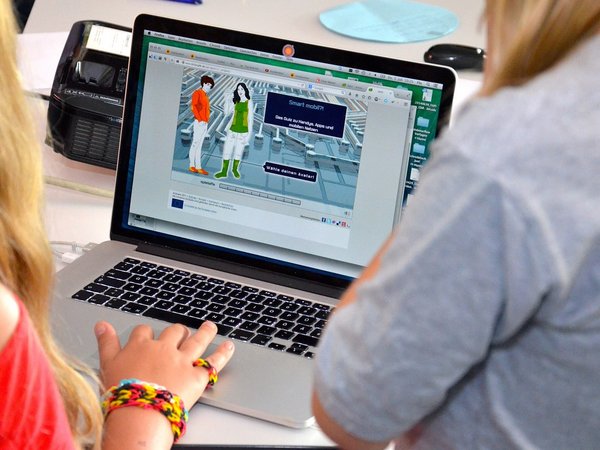Zwei Personen vor einem Laptop