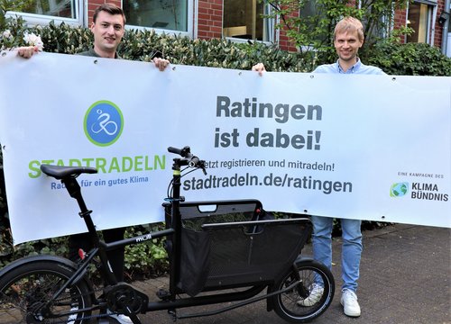 Zwei Männer halten ein Plakat hoch