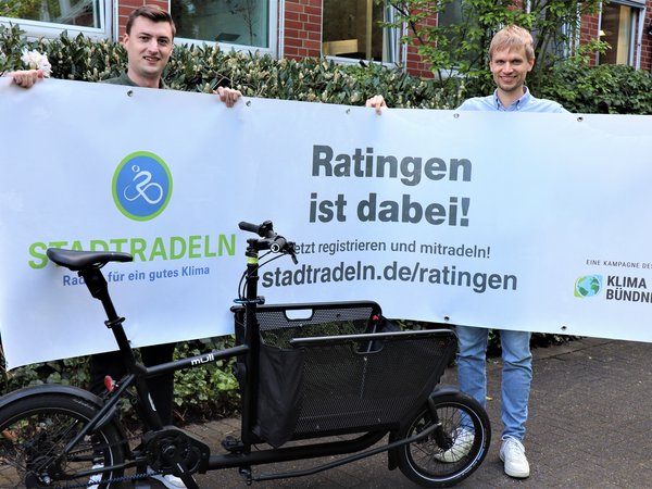 Zwei Männer halten ein Plakat hoch