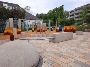 Parkouranlage aus Beton, der Beton ist mit einem Graffiti-Kunstwerk bemalt. Zu sehen sind die Silhouetten von Häusern und Menschen, die den Parkour-Sport betreiben
