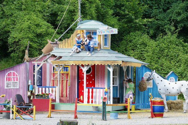 Buntes Haus mit Pferd und Schauspielern.