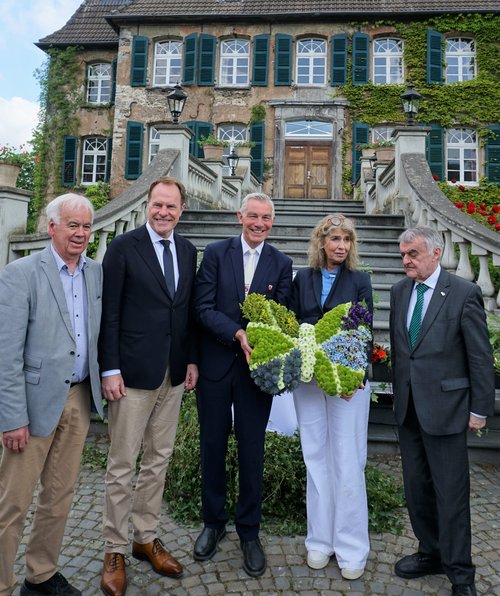 Personengruppe vor einem Schloss