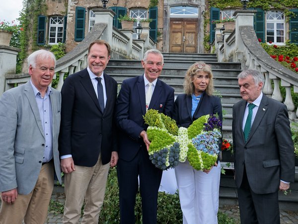 Personengruppe vor einem Schloss