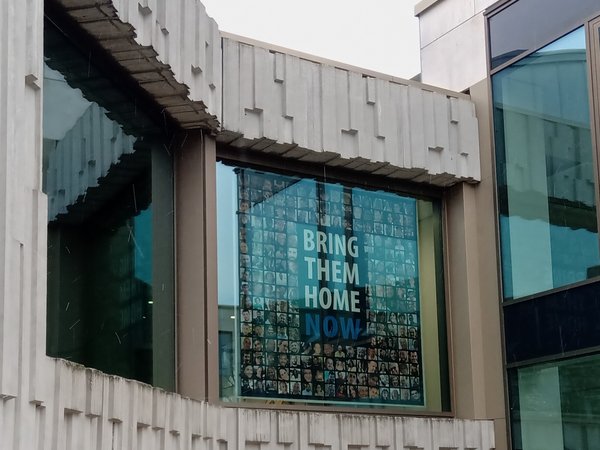 Banner mit dem Appell "Bring them home now" hängt in einem großen Fenster