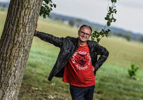 Künstlerporträt: Mann steht an einem Baum gelehnt