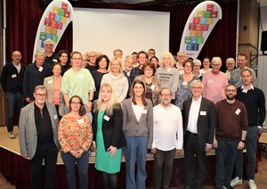 Gruppenfoto der Teilnehmenden des Dialogforum Ratinger Nachhaltigkeitsstrategie in 2015 mit Fahnen "Gemeinsam für ein Nachhaltiges Ratingen" im Hintergrund