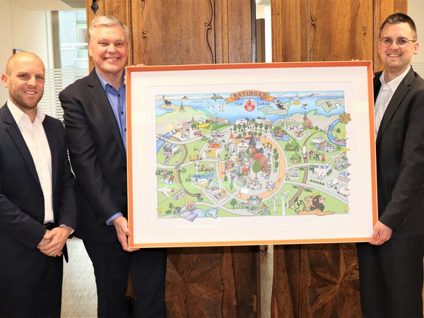 Drei Männer mit einem gerahmten Bild