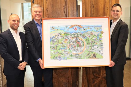 Drei Männer mit einem gerahmten Bild