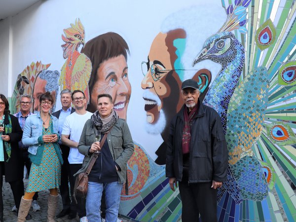 Mehrere Personen vor einer künstlerisch gestalteten Hauswand