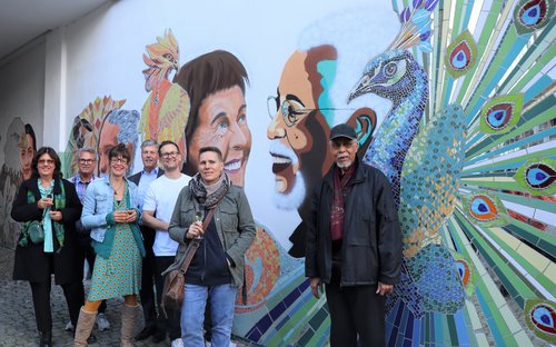 Mehrere Personen vor einer künstlerisch gestalteten Hauswand