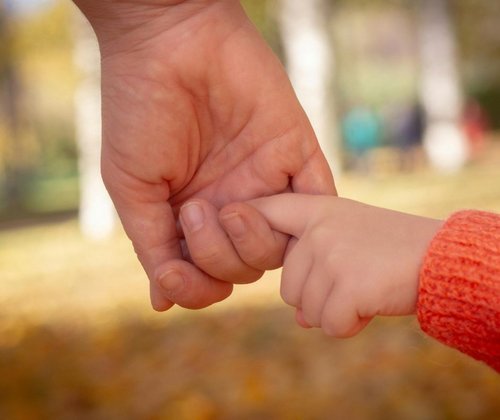 Kinderhand an einer Erwachsenenhand 