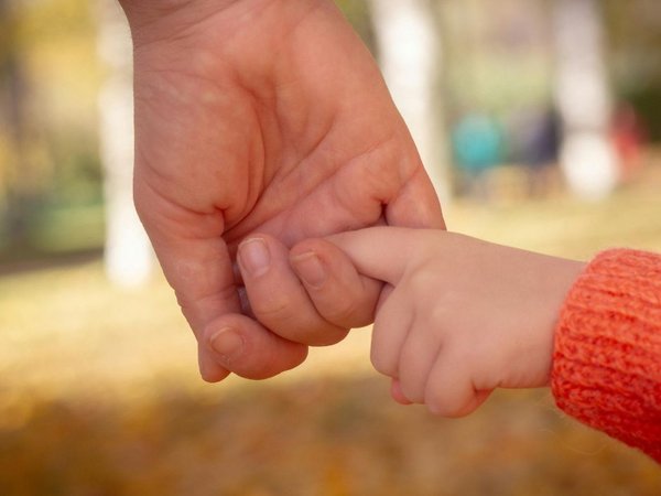 Kinderhand an einer Erwachsenenhand 