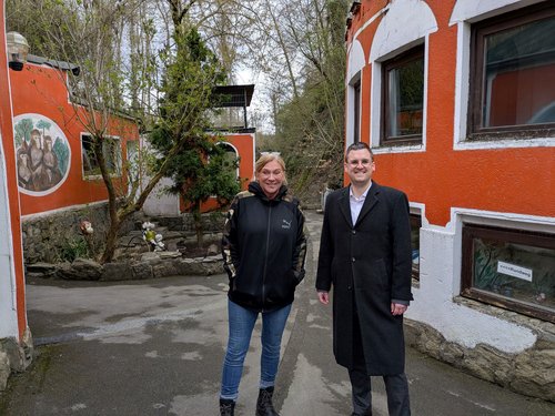 Mann und Frau vor rot gestrichenen Häuschen