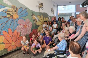 Kinder und Senioren vor dem Mosaik im Durchgang Bechemer Straße