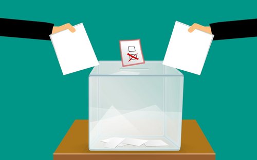 Grafik: Zwei Hände mit Zetteln, davor eine Wahlurne