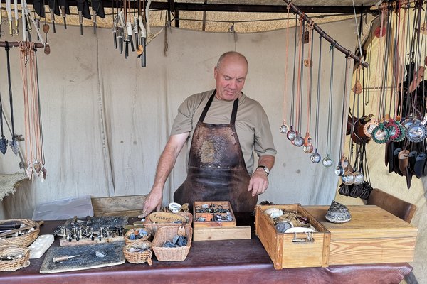 Ein Handwerker zeigt seinen Stand mit historischen Feuerzeugen. 