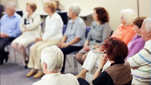 Mehrere Personen sitzen in einem Kreis 