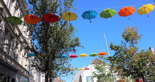Bunte Regenschirme hängen an einer Leine 