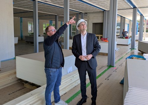 Zwei Männer, einer zeigt mit dem Finger auf etwas