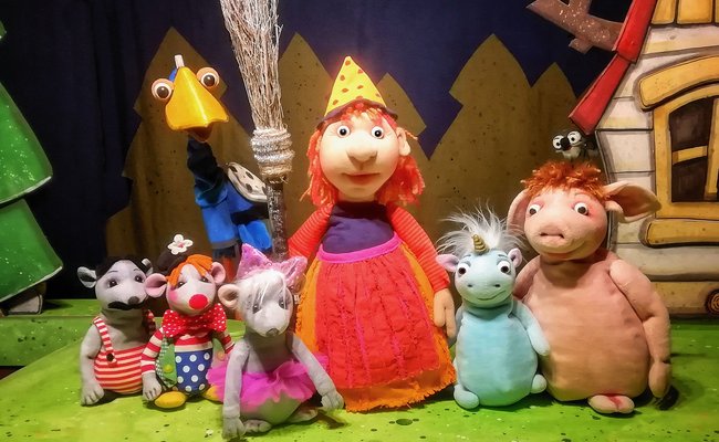 Mehrere bunte Spielzeugfiguren auf einer Wiese