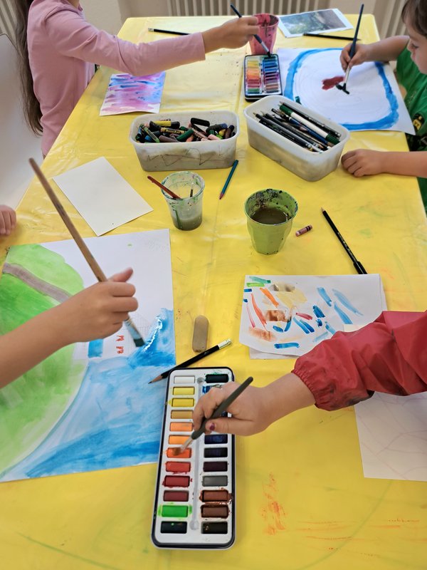 Kinder malen bunte Bilder mit Aquarellfarbe