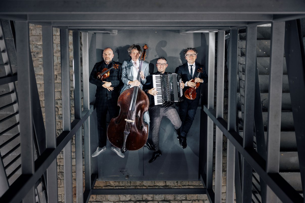 Vier Bandmitglieder mit Instrumenten