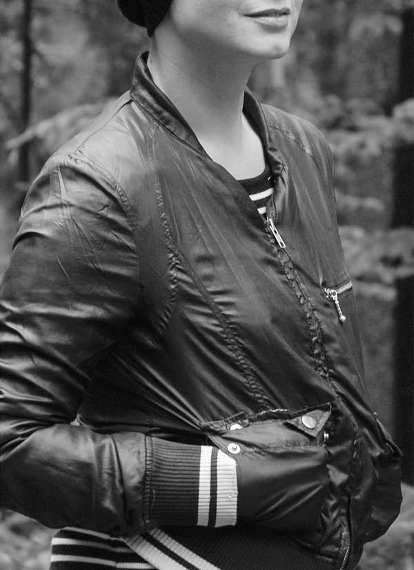 Foto in schwarz-weiß. Junge Frau in Trainigsjacke. 