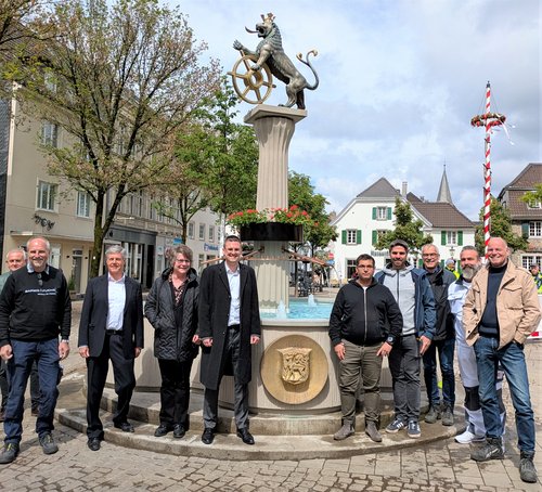 Mehrere Personen stehen vor dem Marktbrunnen