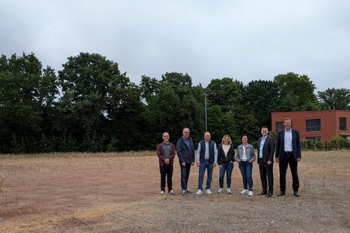 Mehrere Personen auf einem leeren Baufeld