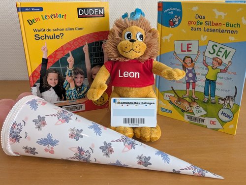 Zwei Bücher, eine Schultüte und ein Plüschlöwe mit Leseausweis der Stadtbücherei
